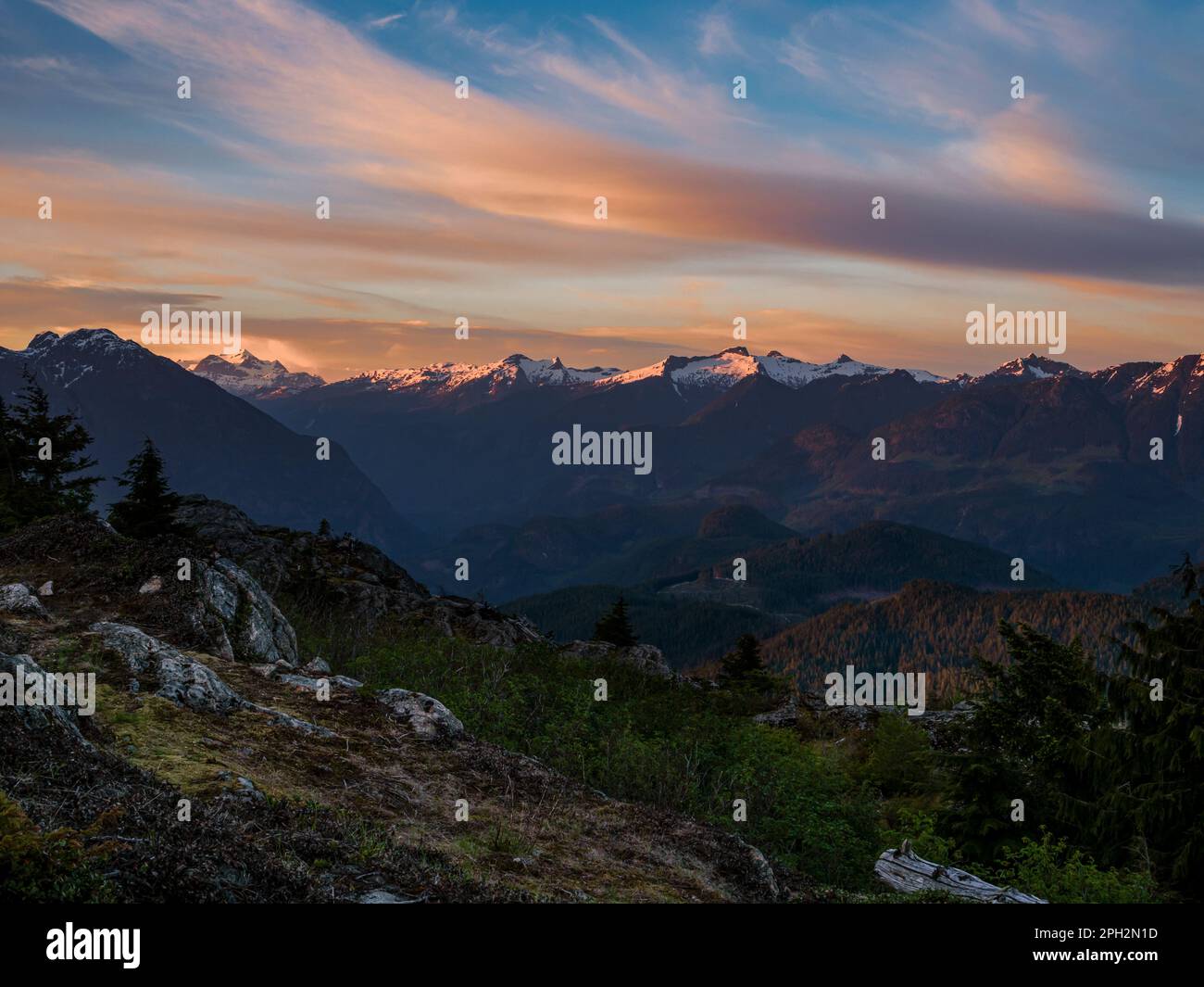 BC00704-00...BRITISH COLUMBIA - Tramonto che porta colore alla catena costiera e nuvole dalla cima del Monte Tin Hat sul Sunshine Coast Trail. Foto Stock