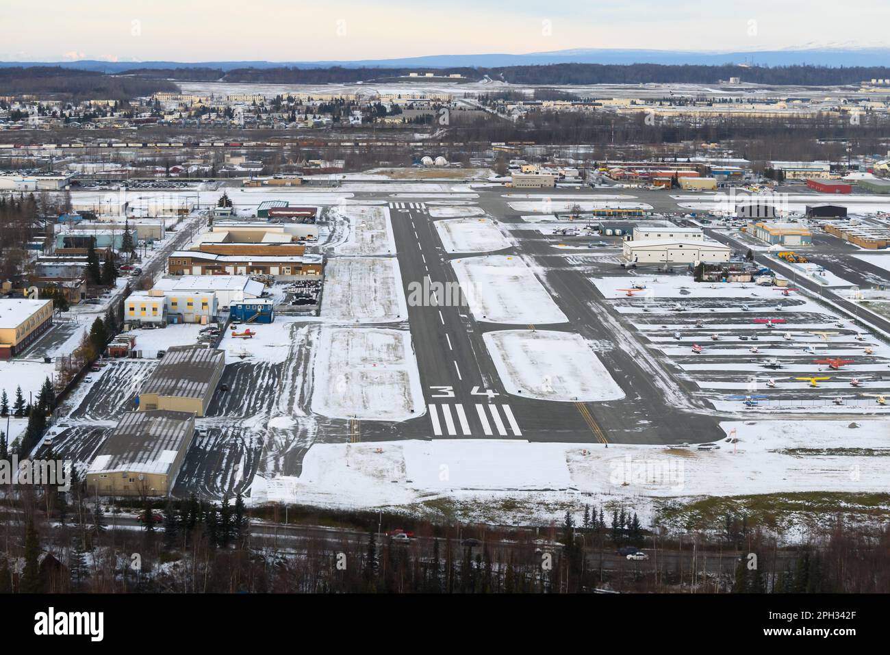 Aeroporto Merrill Field di Anchorage, utilizzato principalmente per l'aviazione generale. Pista di Merrill Field con montagne alle spalle. Foto Stock