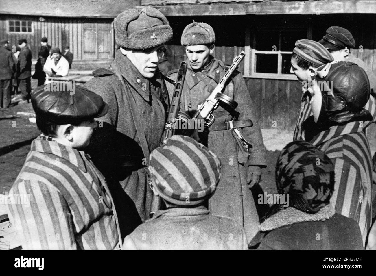 Soldati dell'esercito sovietico che chiacchierano con i bambini appena liberati dal campo di concentramento di Auschwitz Foto Stock