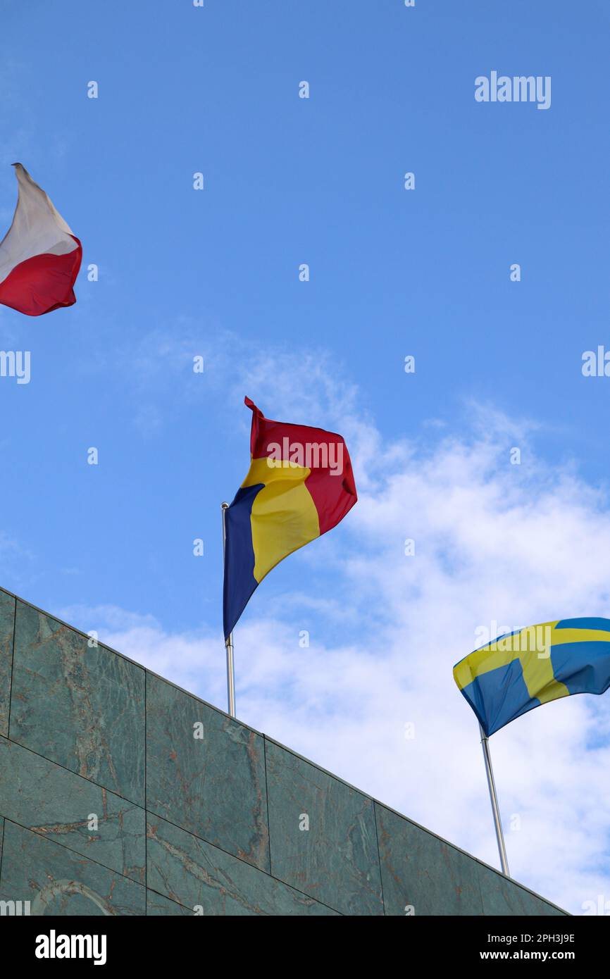 La bandiera rumena sventolava in cima all'edificio con altre bandiere delle Nazioni Foto Stock