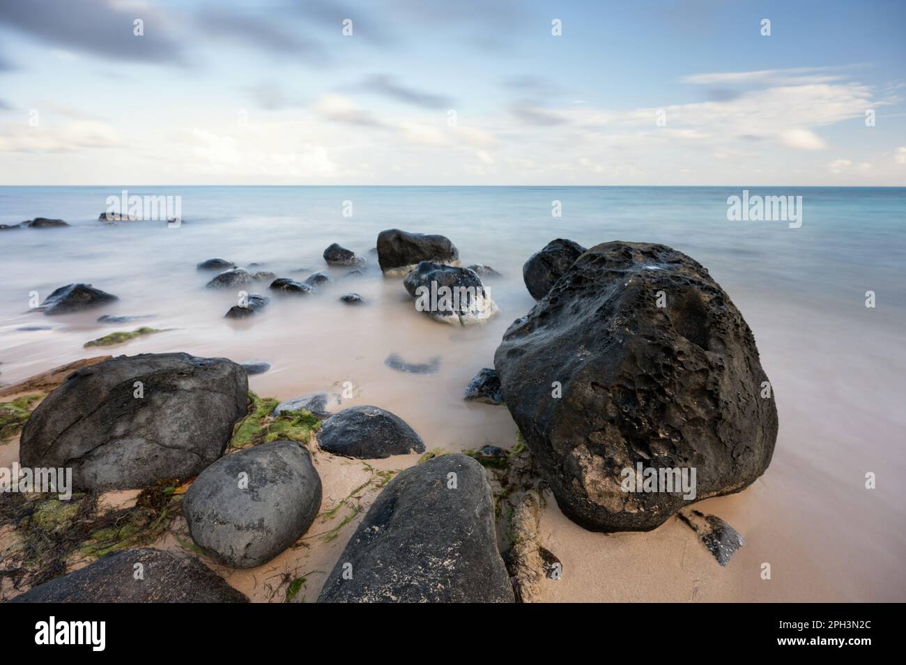 Rocce di pietra sulla spiaggia liscia acqua sfondo caraibico Foto Stock