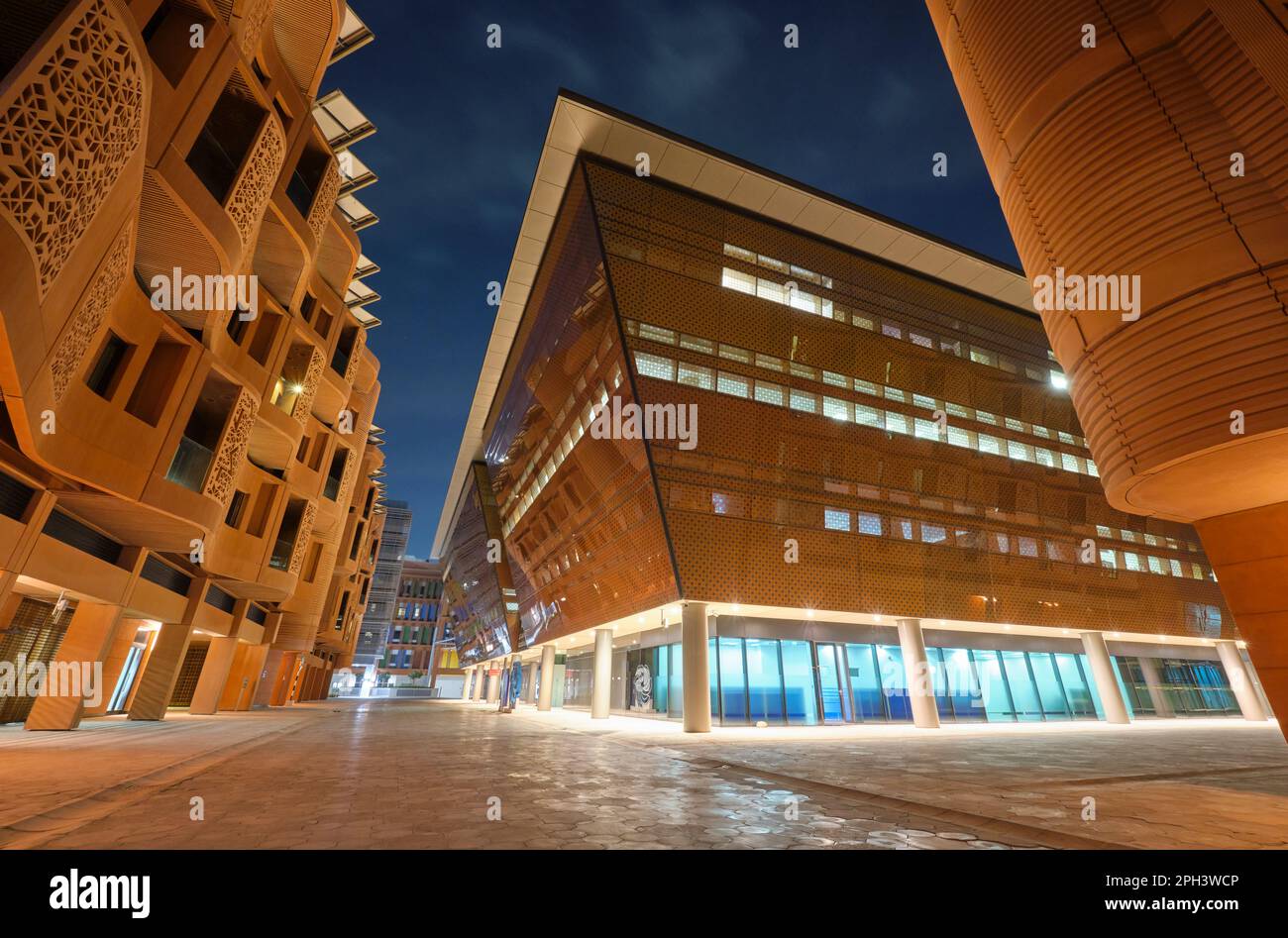 Vista delle aree pedestiane della plaza con architettura di notte. A Masdar City, una comunità prepianificata, verde, sostenibile e consapevole del cambiamento climatico. Ad Abu DH Foto Stock