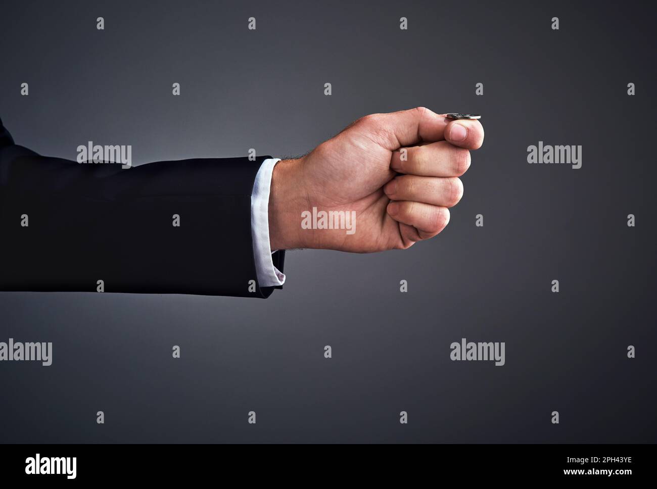 Giocare non sicuro doesnt sempre portare al successo. Ripresa da studio di un uomo d'affari che lancia una moneta su uno sfondo grigio. Foto Stock