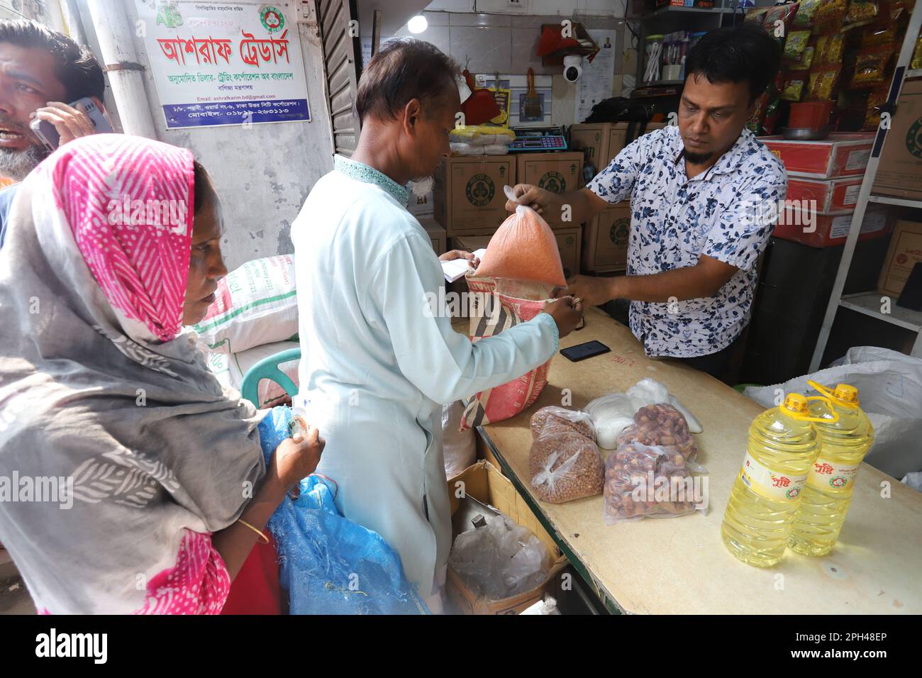 Bangladesh Trading Corporation vende i prodotti alimentari necessari a prezzi agevolati. La gente affollano un negozio di TCB per comprare le merci la mattina presto. Foto Stock