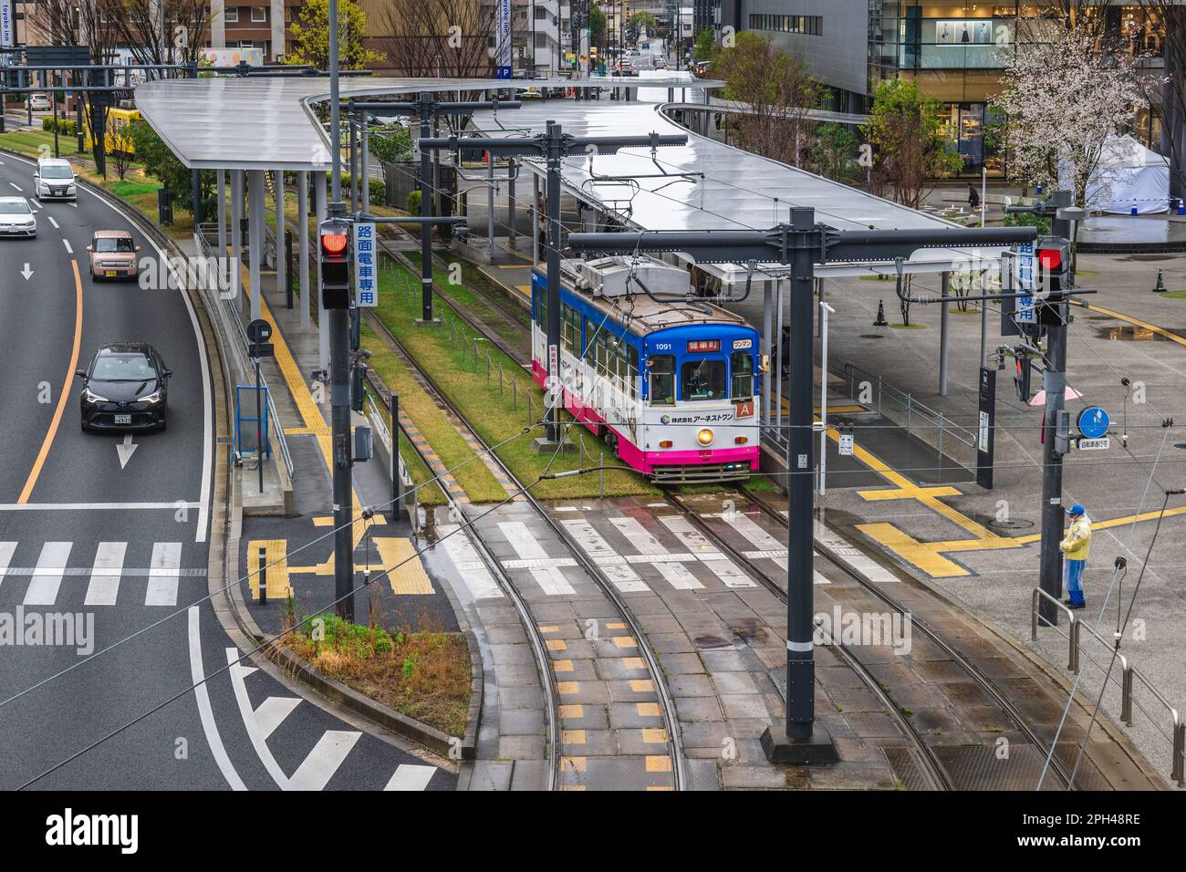 21 marzo 2023: Treno di Kumamoto City Tram fermata di fronte alla stazione ferroviaria di Kumamoto a Kyushu, Giappone. Ci sono cinque linee nel conteggio ufficiale, bu Foto Stock