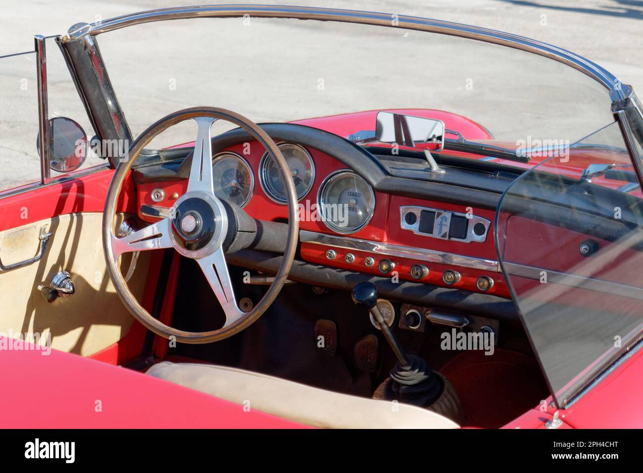 Cruscotto di una vecchia auto classica italiana . Vista particolare del volante e del quadro della strumentazione del veicolo . La vettura è un modello Alfa Romeo Foto Stock