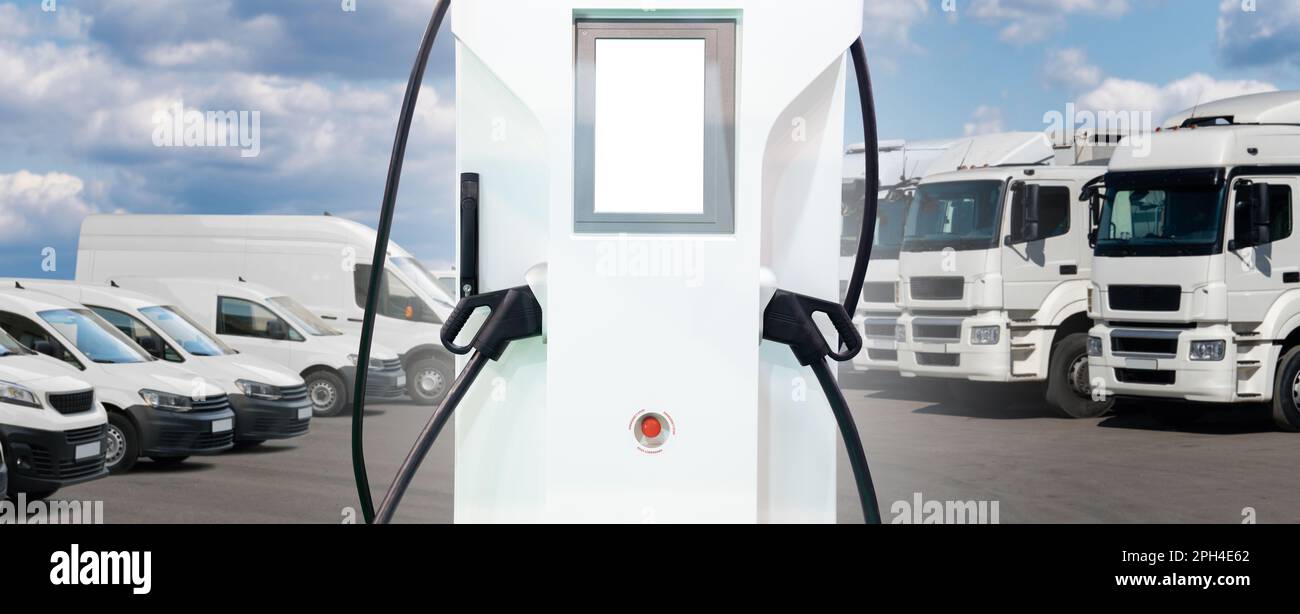 Stazione di ricarica dei veicoli elettrici su uno sfondo di camion e furgoni. Concetto di flotta verde. Foto di alta qualità Foto Stock