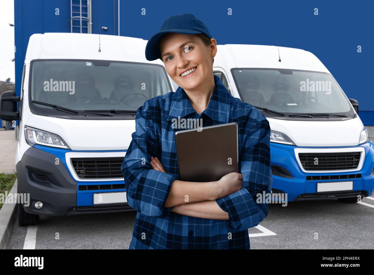 Manager con un tablet digitale sullo sfondo dei furgoni. Gestione della flotta. Foto Stock