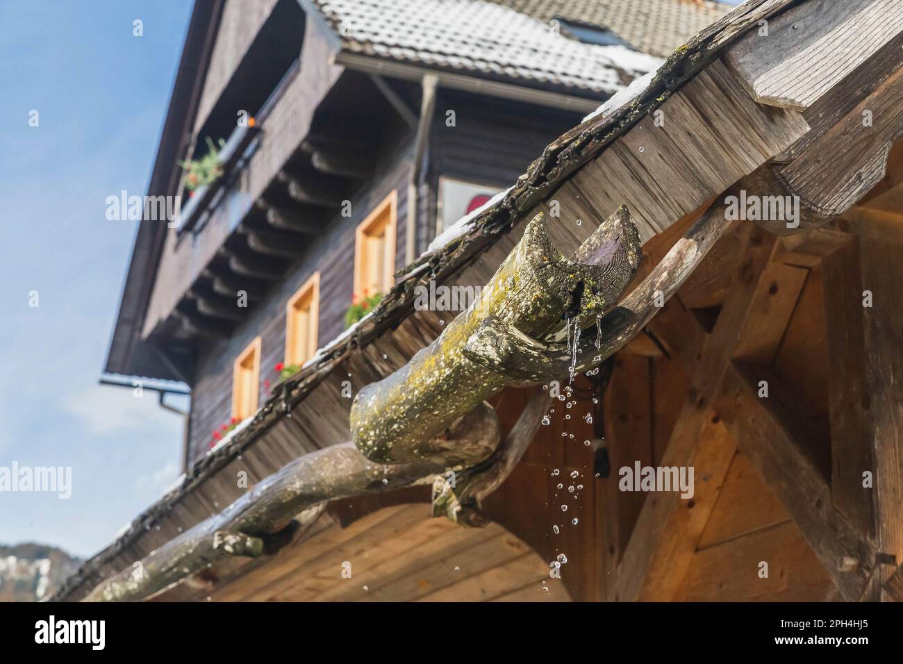 Vecchia grondaia di legno in un villaggio alpino Foto Stock