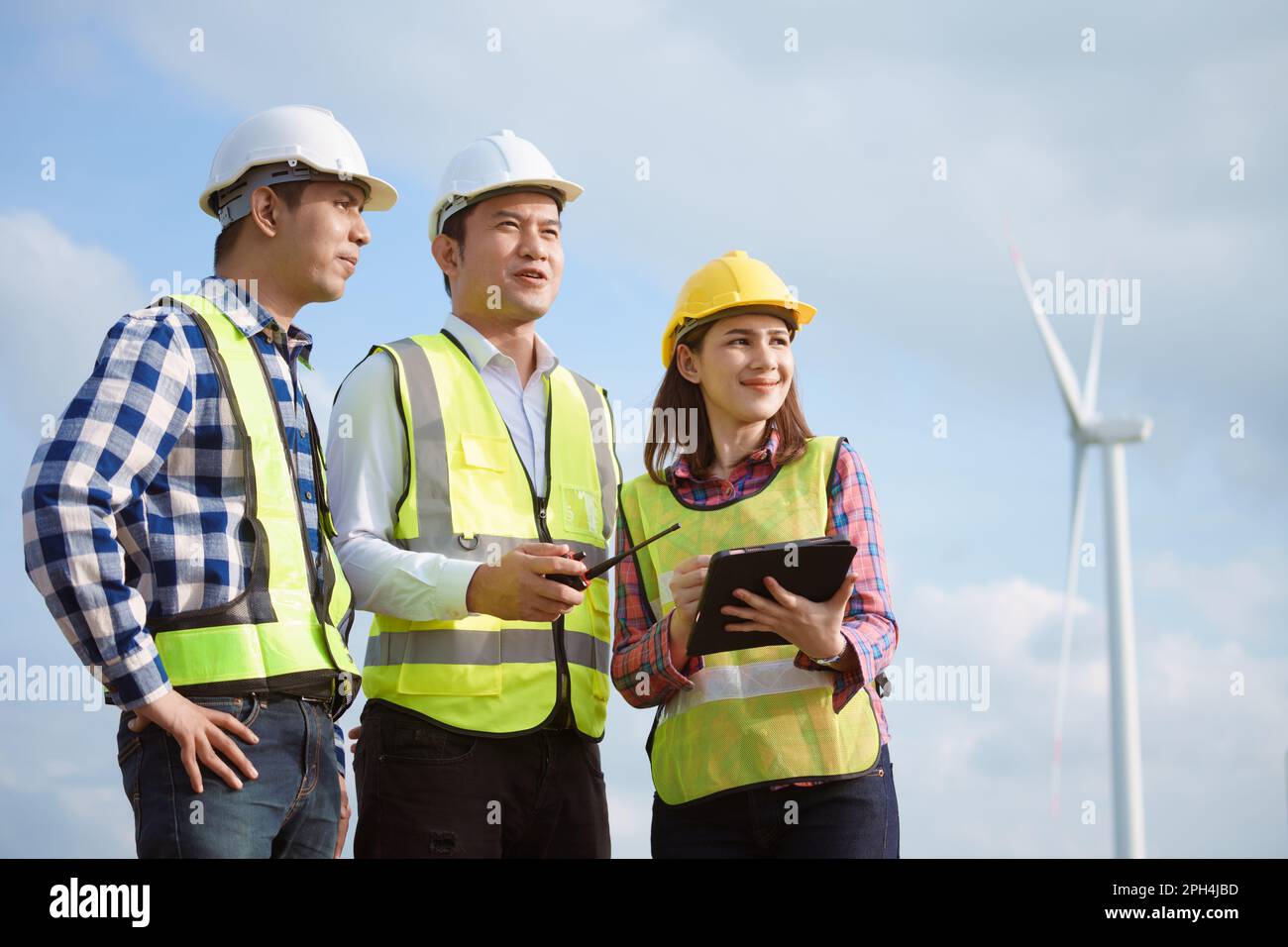 Team di ingegneri asiatici che discutono e controllano le turbine nella fattoria di turbine eoliche. Tecnologia e sostenibilità delle energie rinnovabili. Foto Stock Team di ingegneri asiatici che discutono e controllano le turbine nella fattoria di turbine eoliche. Tecnologia e sostenibilità delle energie rinnovabili. Foto Stock