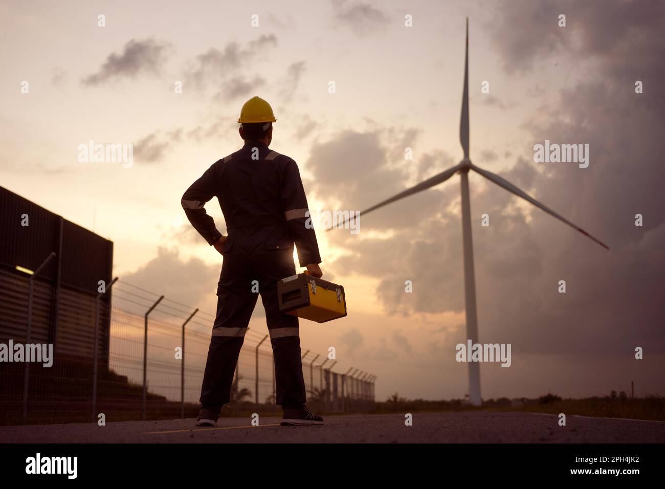 Uomo asiatico ingegnere preparazione e controllo di una turbina eolica con sicurezza in fattoria eolica. Foto Stock Uomo asiatico ingegnere preparazione e controllo di una turbina eolica con sicurezza in fattoria eolica. Foto Stock