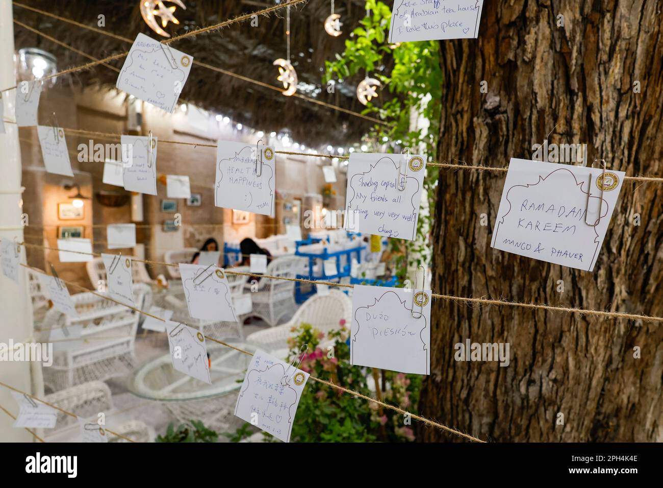 Durante il Ramadan, i clienti segnano delle piccole note presso l'Arabian Tea House, nel quartiere storico di al Fahidi, Dubai, Emirati Arabi Uniti. Foto Stock