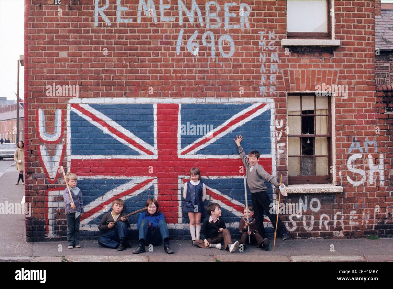 I bambini esprimono fedeltà alla forza volontari dell'Ulster da un murale dell'Union Jack and Remember 1690, Shankill Road, Belfast, Irlanda del Nord. 1972 Foto Stock