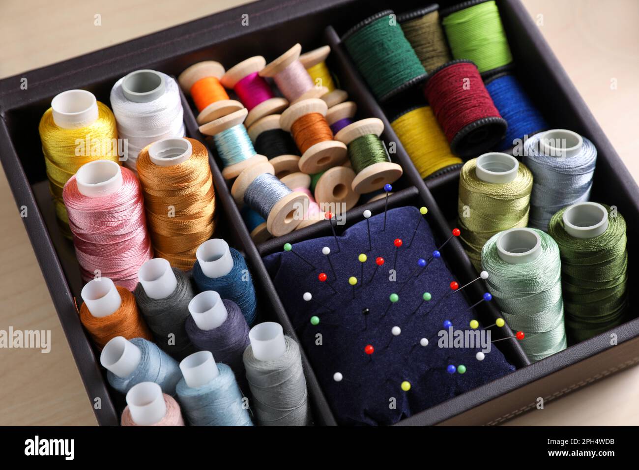 Set di fili da cucire e cuscino con spille in organizer, primo piano Foto  stock - Alamy
