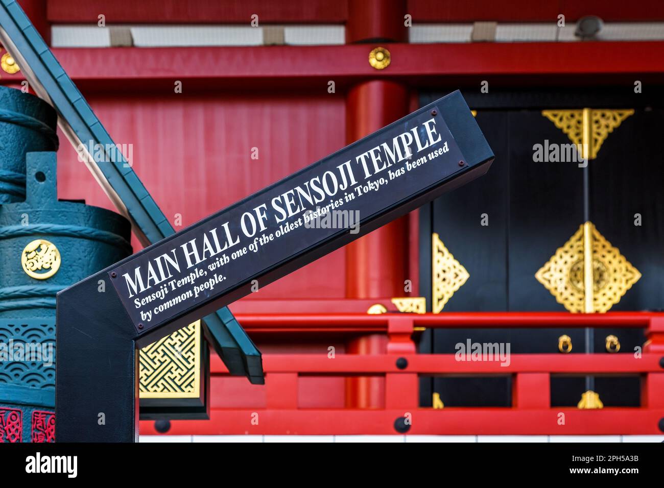 Tokyo, Giappone - 20 giugno 2016: Cartello della Sala principale del Tempio di Sensoji. Primo piano con i dettagli del santuario rosso e oro dietro. Foto Stock