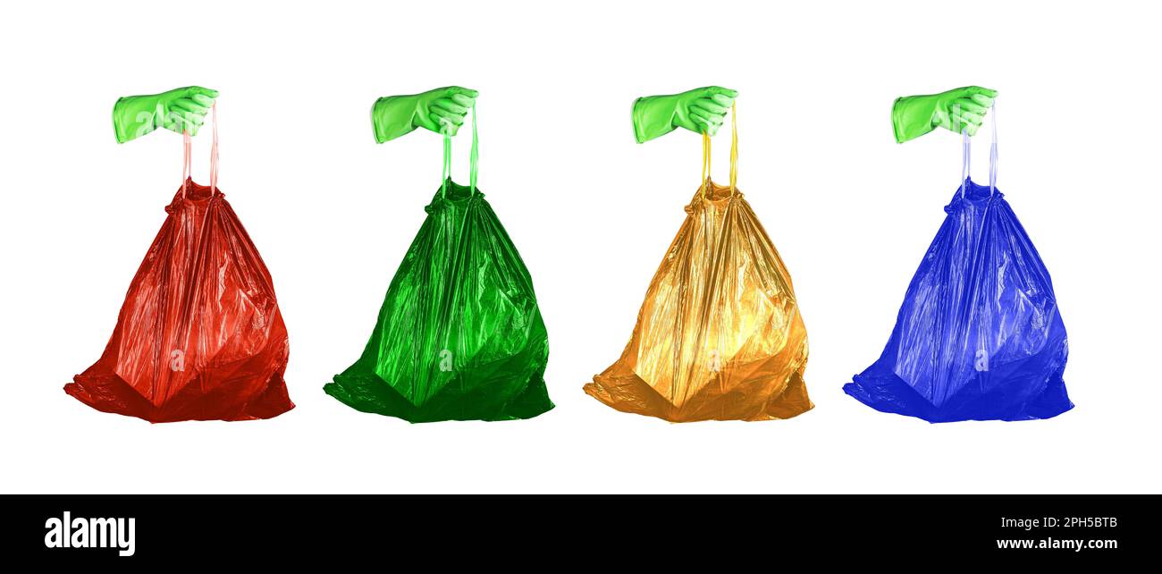 Concetto di ordinamento dei rifiuti. Mani che tengono sacchetti di rifiuti di diversi colori per vari tipi di rifiuti, rosso, verde, giallo e blu. Foto Stock