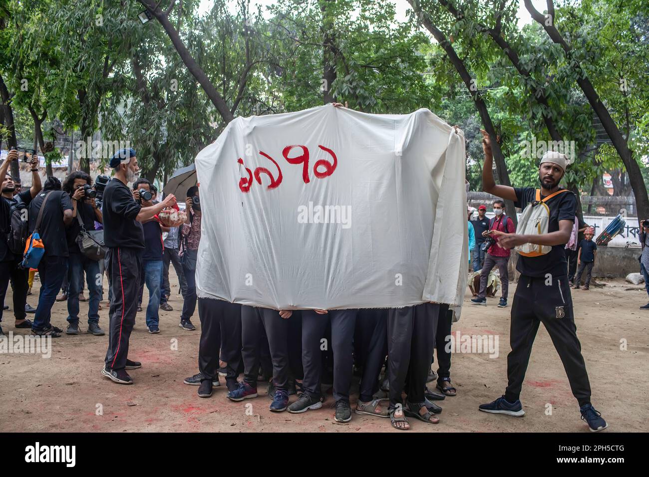 Scuola di artisti di recitazione e design di Prachyanat, vista durante un'esibizione di Lal Jatra (processione Rossa) presso il campus dell'Università di Dhaka. La Scuola di recitazione e disegno di Prachyanat ha tenuto una processione di Lal Jatra (Processione Rossa), per ricordare il genocidio dell'esercito pakistano il 25 marzo 1971 a Dhaka, Bangladesh, il 25 marzo 2023. In questa notte nera nella storia nazionale, i governanti militari pakistani hanno lanciato ''operazione Searchlight'' uccidendo circa mille persone solo in quella notte di repressione. Nell'ambito dell'operazione, i carri armati sono usciti dal dhaka cantonment e una città addormentata si è svegliata ai battiti Foto Stock