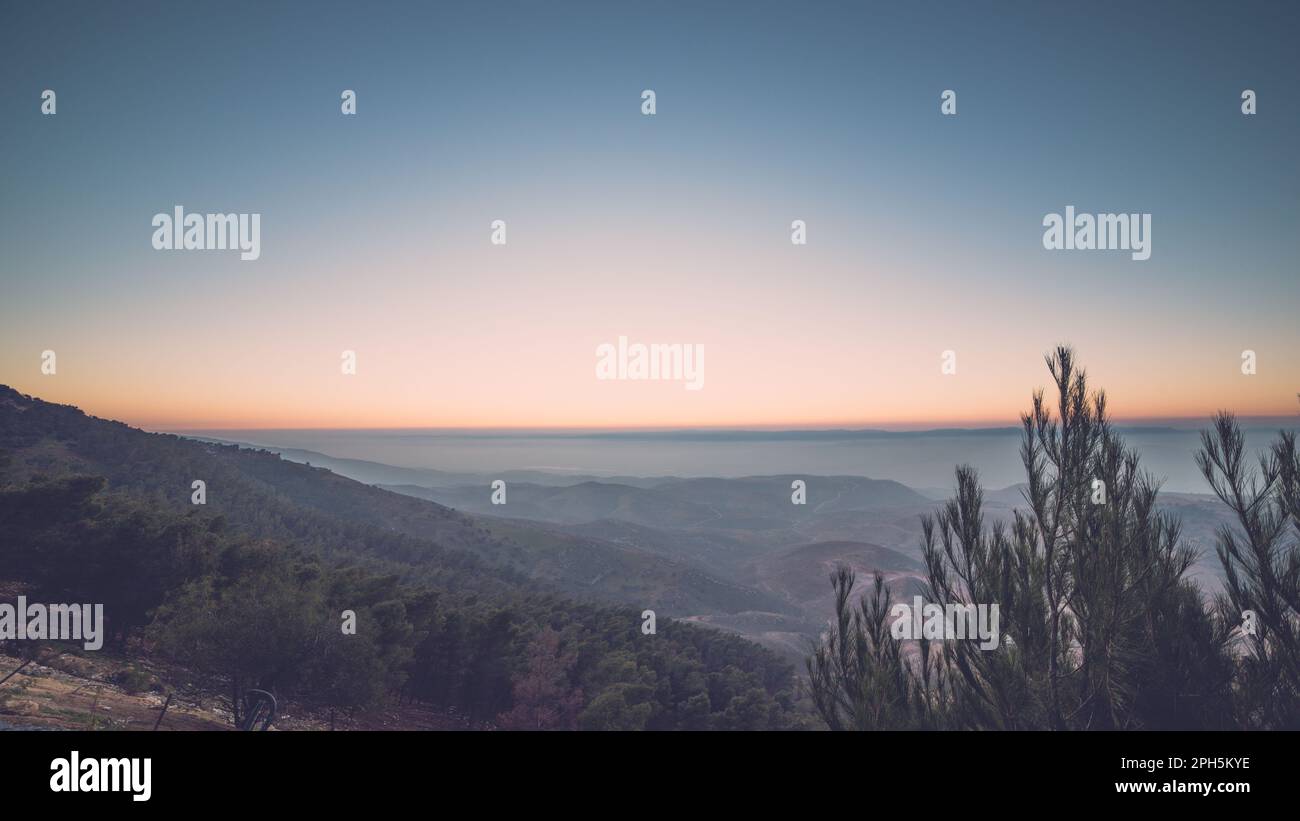 orizzonte del tramonto con una montagna di pineta Foto Stock