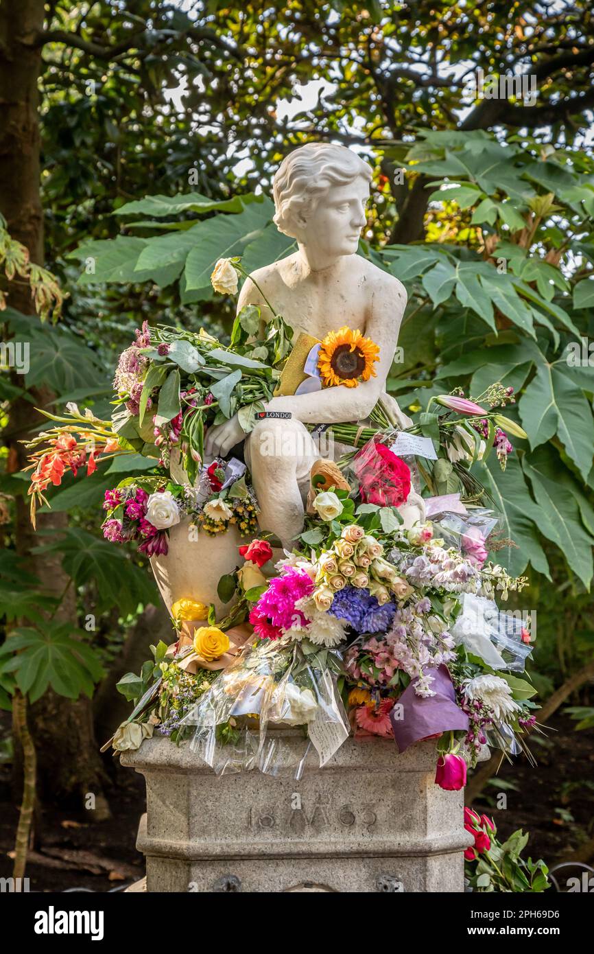 La statua del ragazzo è ricoperta di fiori durante il periodo del lutto per la Regina Elisabetta II, St James Park, Londra, Regno Unito Foto Stock