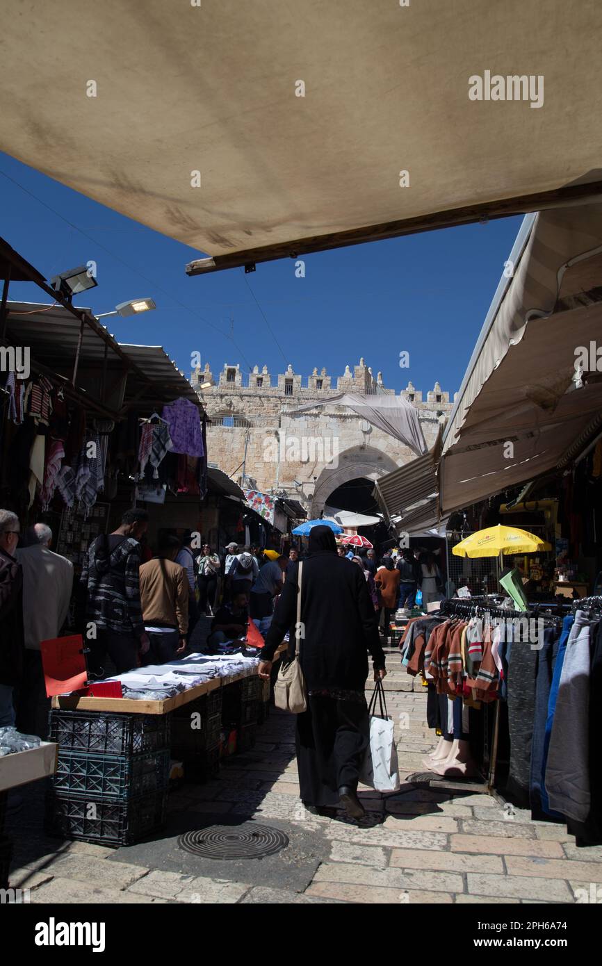 Una donna in un burka cammina tra le bancarelle e i negozi nella Vecchia Gerusalemme Israele Foto Stock