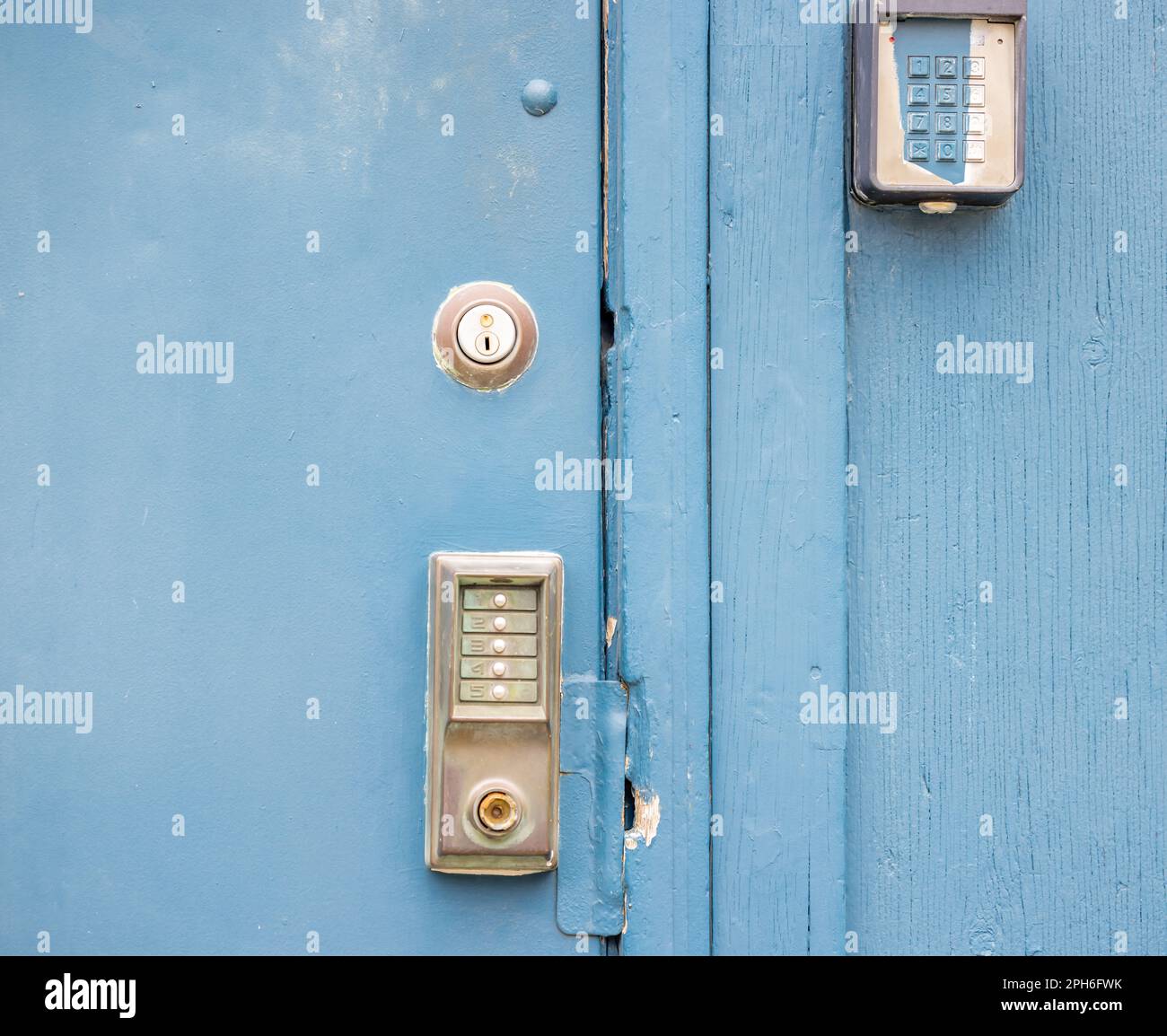 Immagine in primo piano di diversi tipi di serrature su una porta esterna di metallo blu. Foto Stock