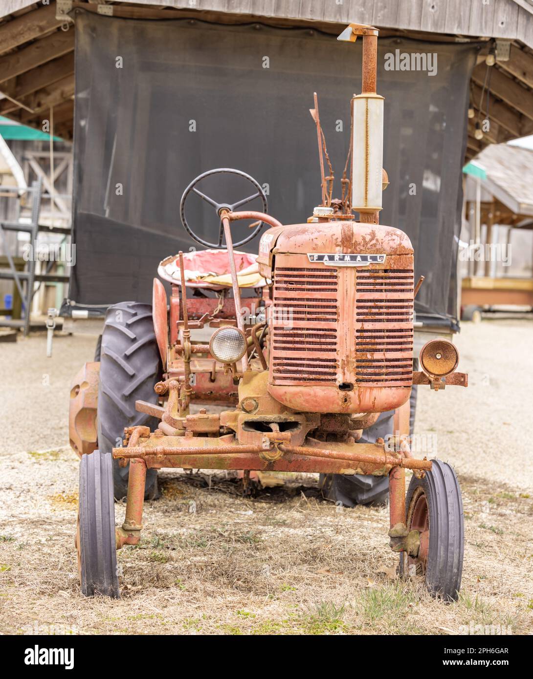 Un antico motore Farmall disassato, un trattore per coltivazione a file con aratro Foto Stock
