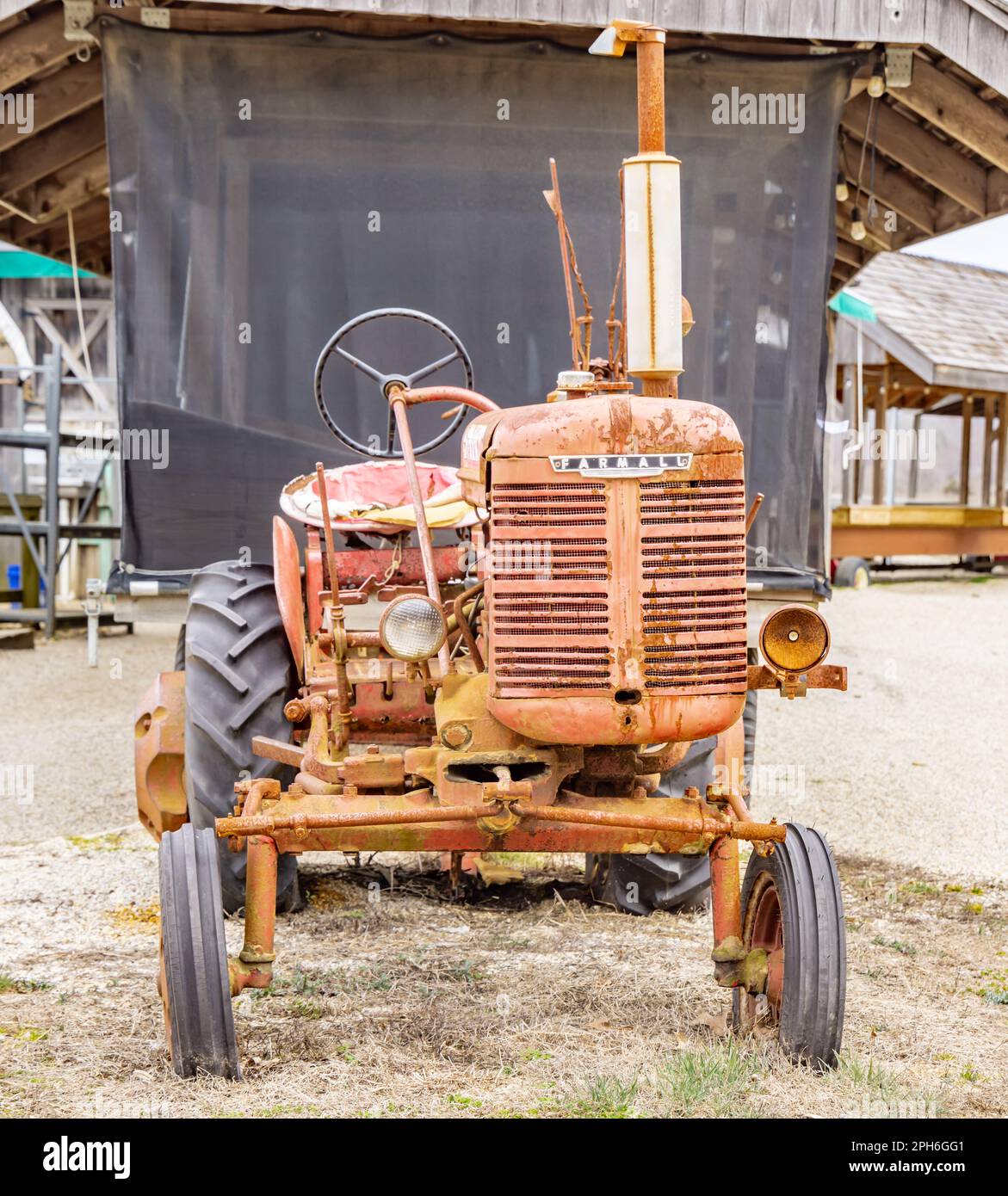 Un antico motore Farmall disassato, un trattore per coltivazione a file con aratro Foto Stock