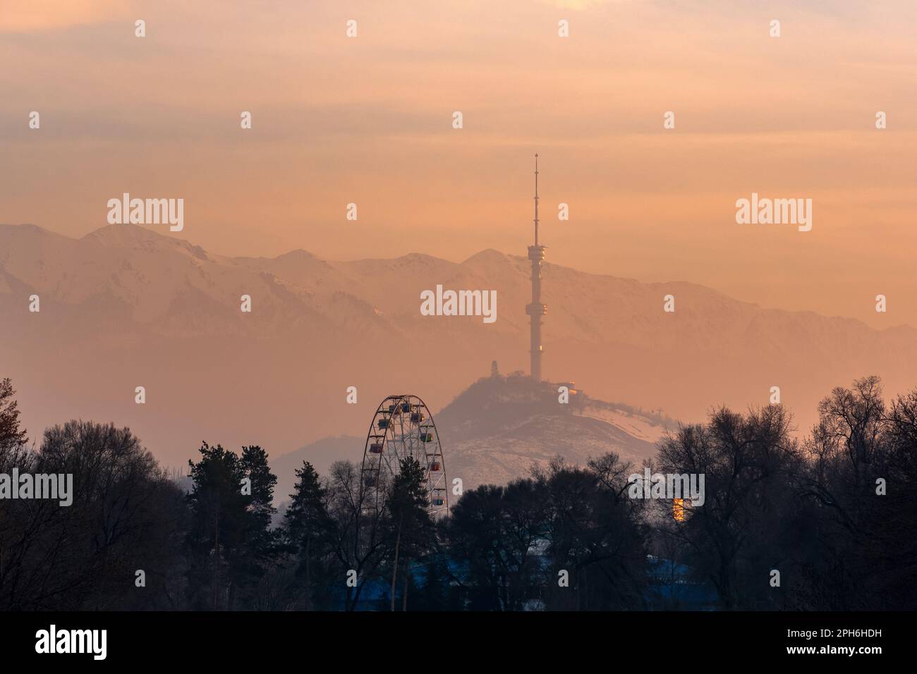 Almaty, Kazakhstan - 07 gennaio 2023: Tramonto invernale vista dal parco della città al monte Koktobe con torre televisiva Foto Stock