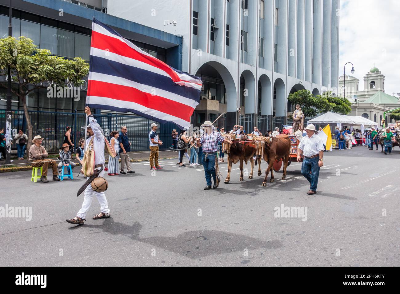 Uomo che indossa abiti tradizionali con una bandiera costaricana in una parata di bue cart a San José. Foto Stock