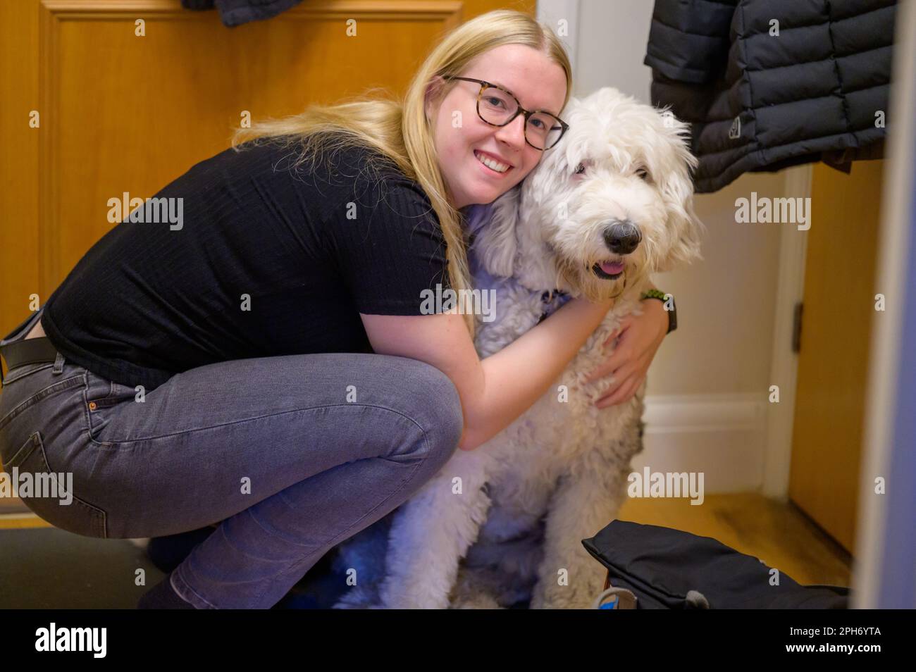 Una donna condivide un momento di amore e affetto con la sua amica, un bel cane da pastore inglese antico. Foto Stock