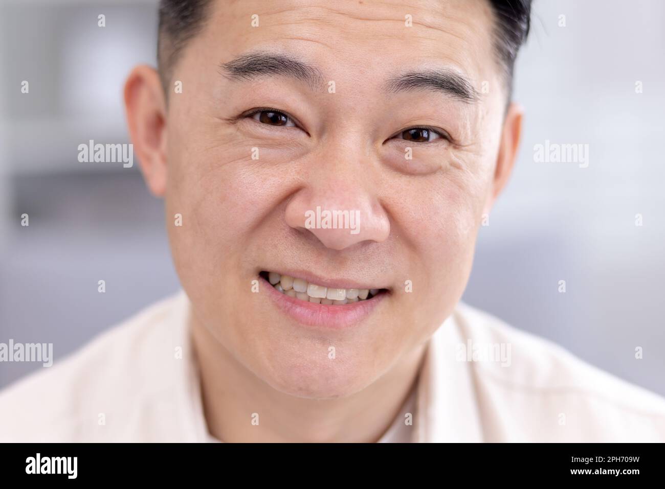 Primo piano di un uomo asiatico, ritratto di un uomo d'affari maschio, guardando la fotocamera e sorridendo alla testa. Foto Stock