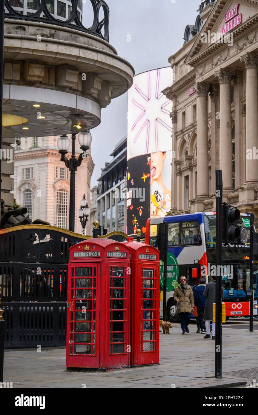 LONDRA - 13 novembre 2022: Le tradizionali cabine telefoniche rosse di Piccadilly Circus a Londra sono un simbolo del patrimonio britannico e un turista popolare Foto Stock