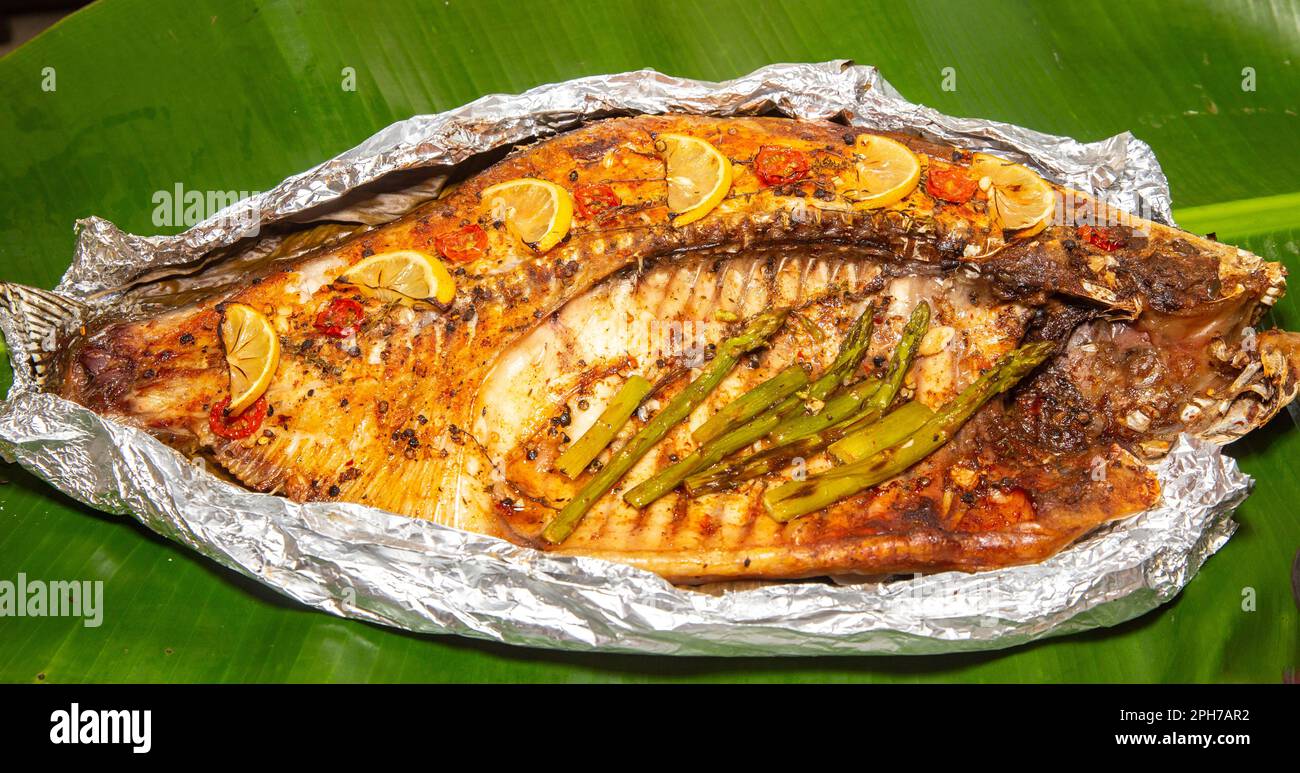 Tambaqui (Colossoma macromomomon) pesce d'acqua dolce brasiliano tradizionale dell'Amazzonia e Pantanal, su foglia di banana. Foto Stock