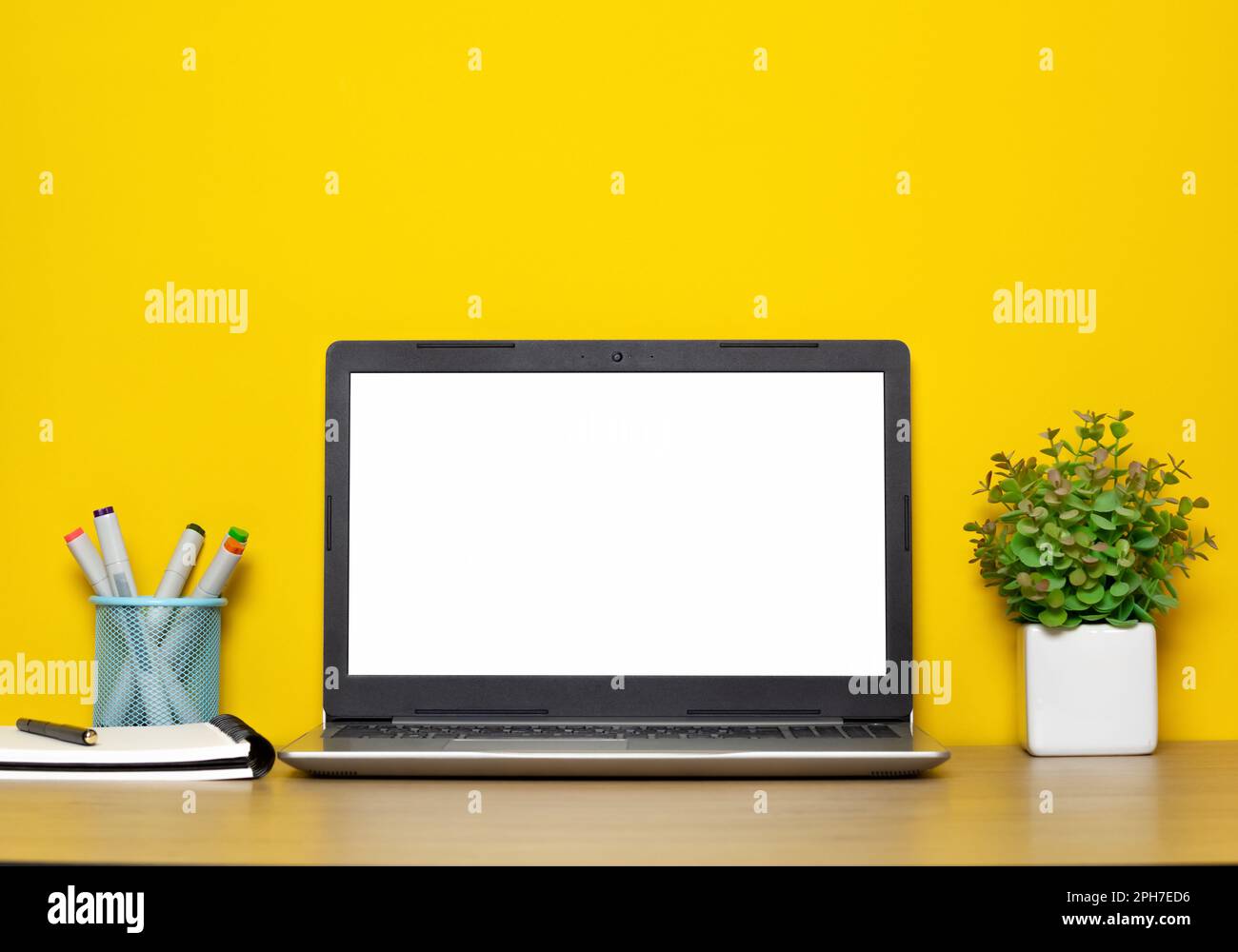 Computer portatile con schermo bianco vuoto su sfondo giallo del desktop. Foto Stock