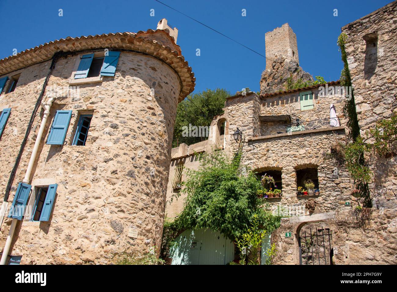 La torre medievale Tour de Guep è stata costruita in alto su una collina della valle del fiume Orb che custodisce il vecchio villaggio Roquebrun nel sud della Francia. Foto Stock