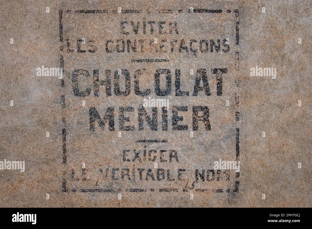 Chocolat Menier: Un segno sbiadito di una marca dimenticata di dolci su una facciata nel vecchio villaggio Roquebrun nella valle del fiume Orb del sud della Francia. Foto Stock