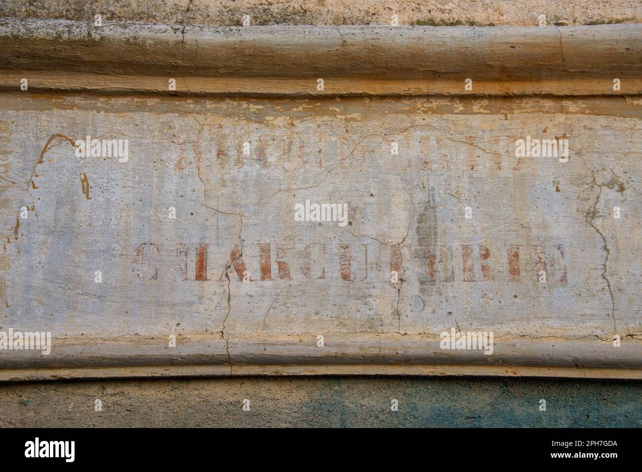 Salumi: Un segno sbiadito di un macellaio su una facciata nel vecchio villaggio Roquebrun nella valle del fiume Orb del sud della Francia. Foto Stock
