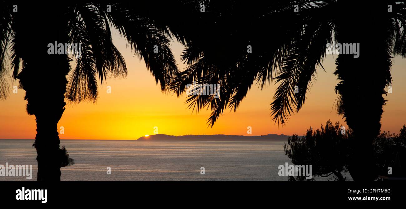 Tramonto dietro l'isola di Santa Catalina al largo della costa dell'Oceano Pacifico di Dana Point, Orange County, California meridionale Foto Stock