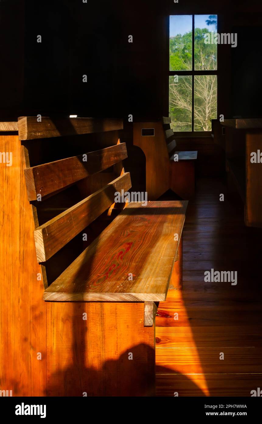 I banchi della scuola in legno vintage riempiono la County Line Schoolhouse, conosciuta anche come Evanston School, nel Lucedale City Park di Lucedale, Mississippi. Foto Stock