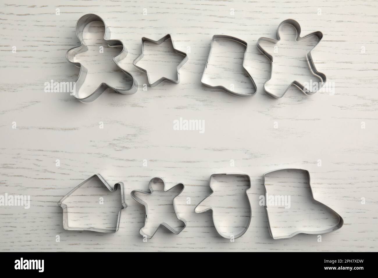 Taglierine per biscotti diverse su un tavolo di legno bianco, piatto. Spazio per il testo Foto Stock