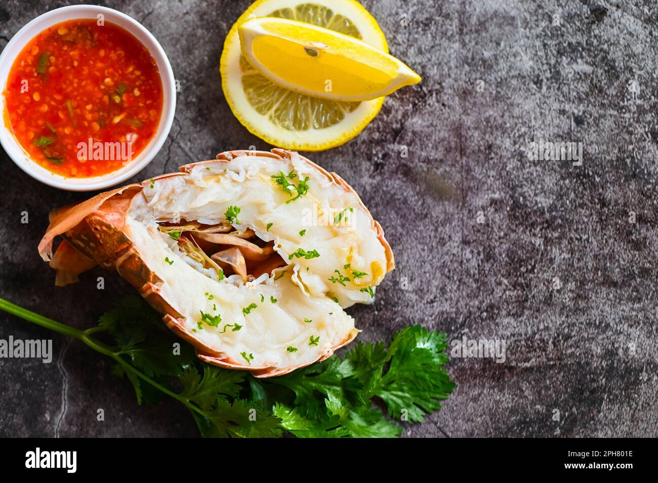 aragosta spinosa sul piatto, aragosta fresca o pesce aragosta con erbe e spezie coriandolo limone prezzemolo insalata di lattuga, aragosta per la cottura foo Foto Stock