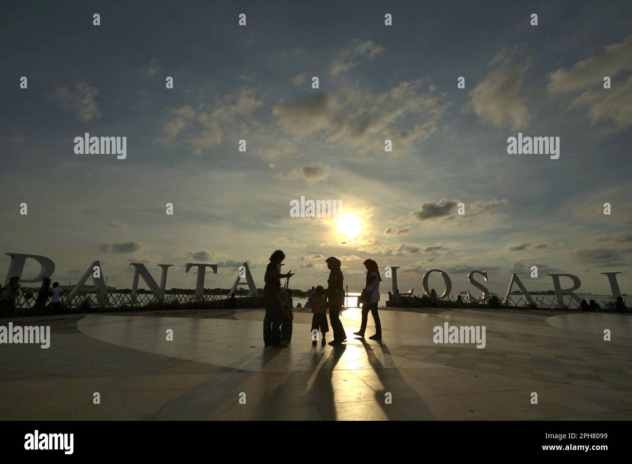 Vista del cielo pomeridiano e delle persone che hanno tempo libero sulla piattaforma balneare di Losari a Makassar, una città costiera che è circondata da controversie sullo sviluppo costiero e la gestione delle risorse costiere nel Sud Sulawesi, Indonesia. Il ripristino o la protezione degli ecosistemi costieri è un'importante azione di adattamento al cambiamento climatico con molteplici vantaggi, con limitati benefici globali di mitigazione, secondo il rapporto del 2023 pubblicato dal Gruppo intergovernativo sui cambiamenti climatici (IPCC), dal titolo "cambiamenti climatici 2022: Impatti, adattamento e vulnerabilità". Foto Stock