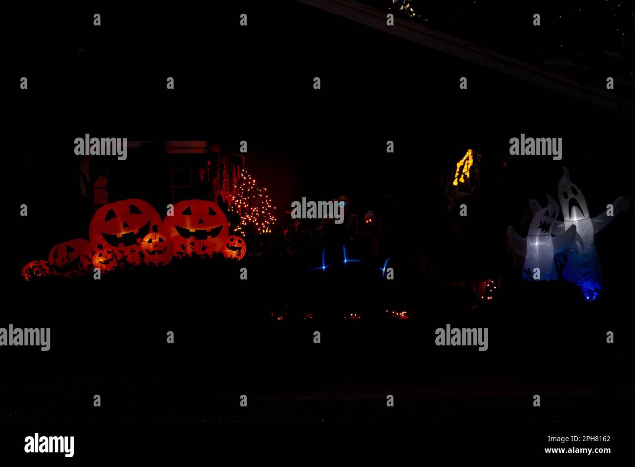 Decorazioni di Halloween all'aperto con fantasmi gonfiabili e lanterne jack o, note anche come zucche intagliate, in un quartiere degli Stati Uniti Foto Stock
