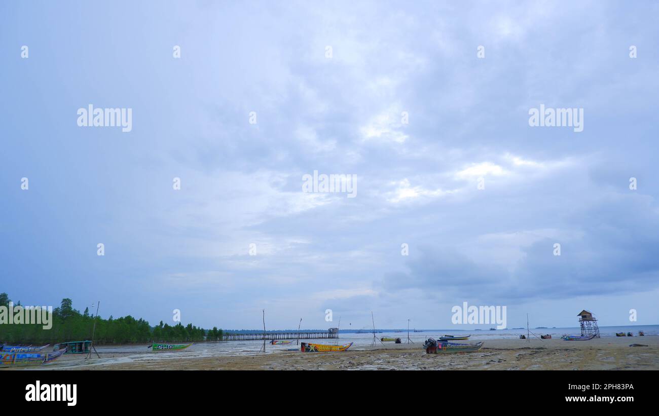 Scenario naturale del cielo blu-grigio con ampia distesa di sabbia e verde foresta, nel villaggio di Belo Laut nel pomeriggio Foto Stock