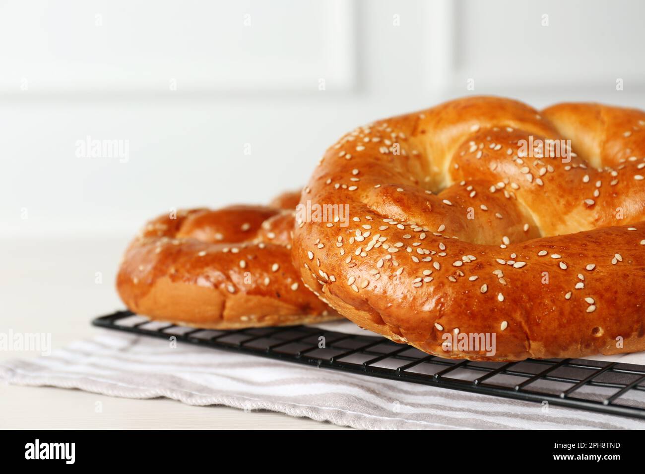 Gustosi pretzel appena sfornati sulla griglia di raffreddamento, vista in primo piano Foto Stock