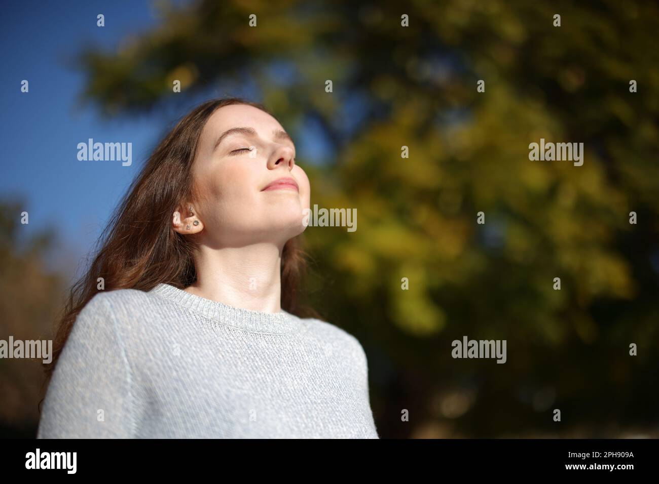 Donna rilassata respirare aria fresca in natura una giornata di sole Foto Stock