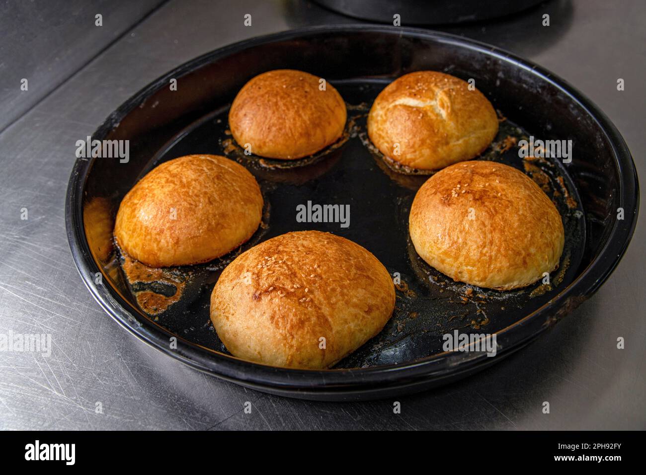 Hamburger panini caldi appena sfornati in un forno industriale Foto Stock