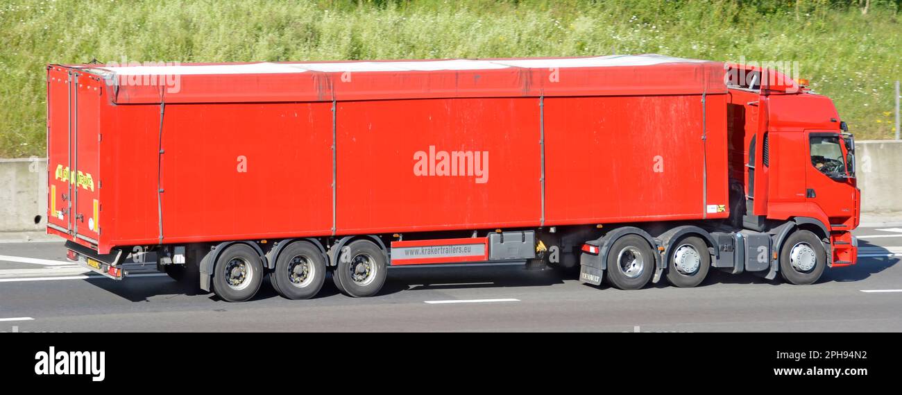 Vista laterale del semirimorchio Renault hgv rosso e del rimorchio rosso con pannello informativo dei rimorchi a pianale mobile Kraker che percorrono l'autostrada M25 del Regno Unito Foto Stock