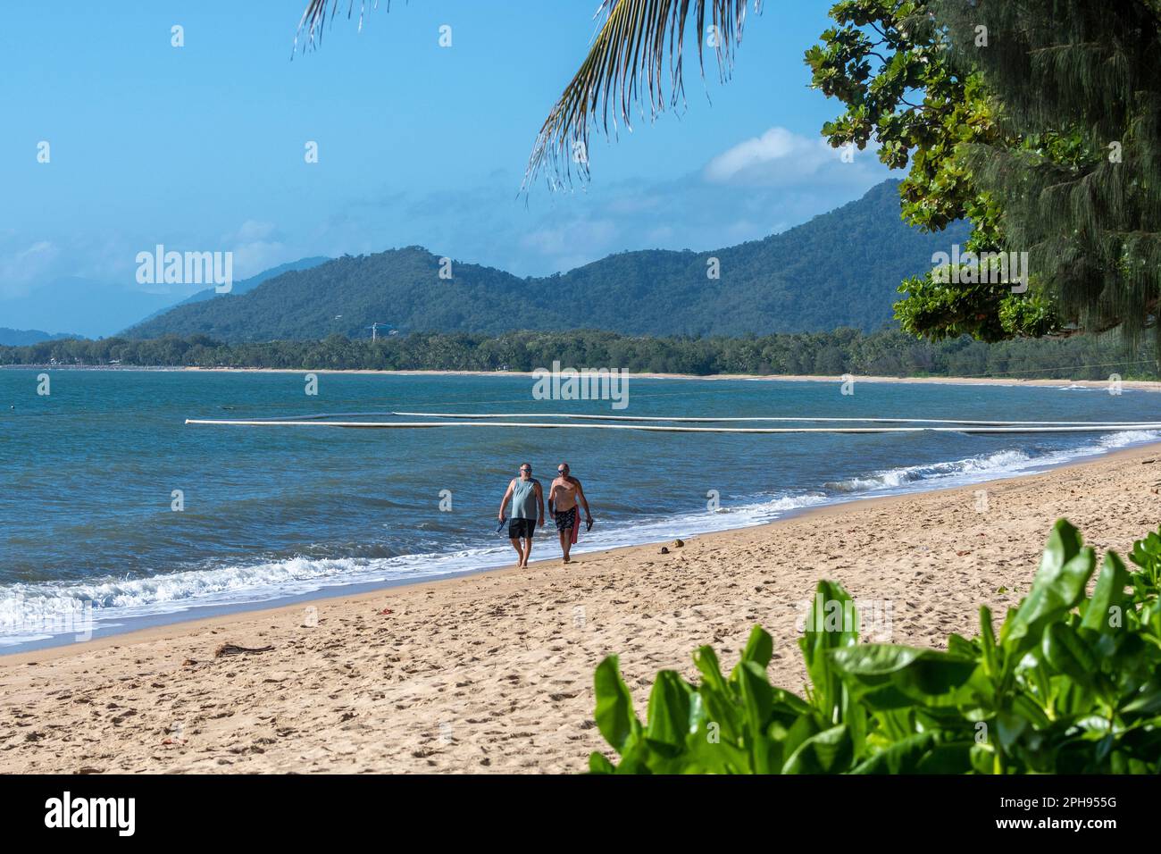 Due uomini che camminano sulla spiaggia di Palm Cove, Cairns Northern Beaches, far North Queensland, FNQ, QLD, Australia Foto Stock