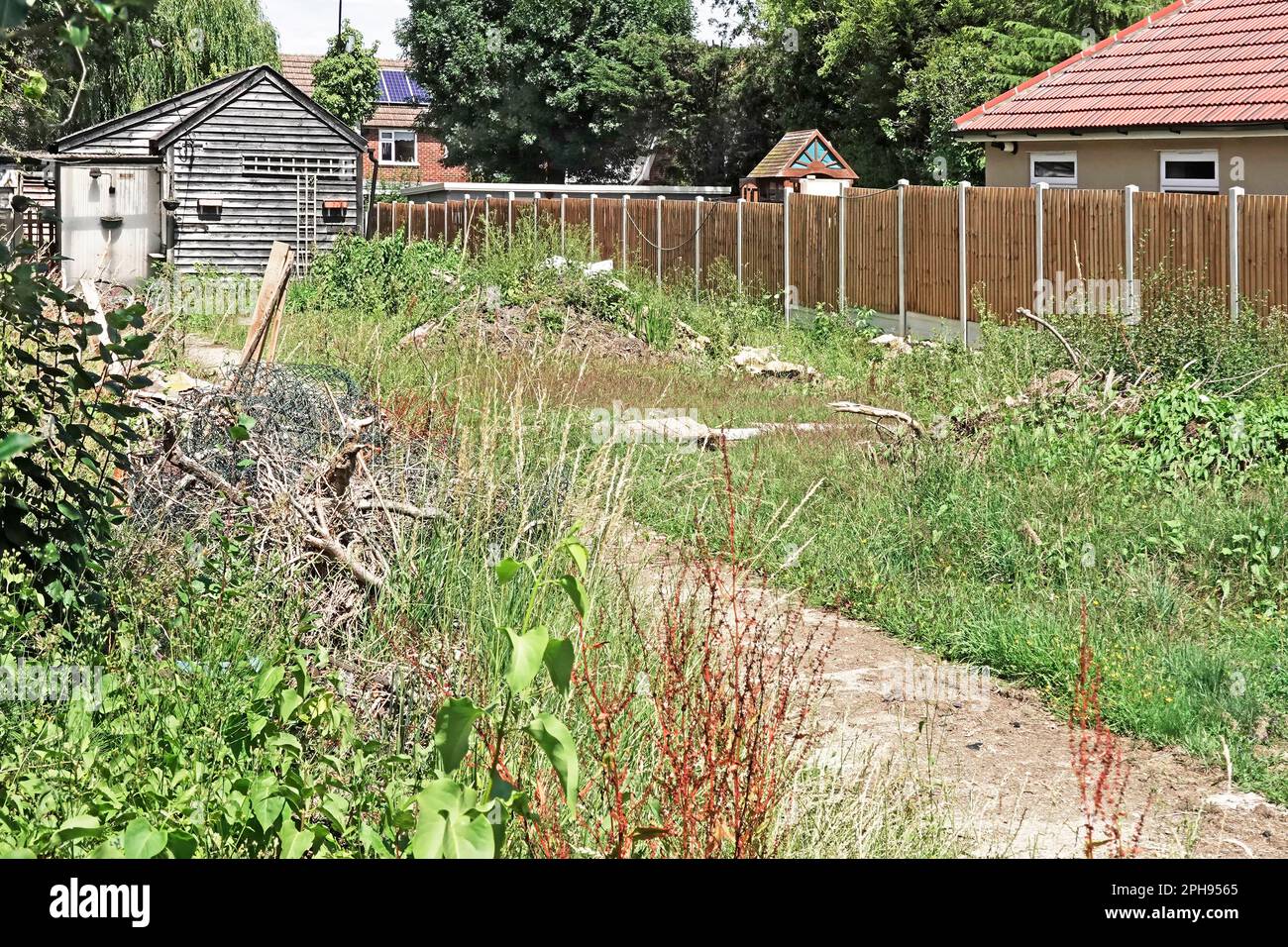 Tra le guerre week-end cottage & giardino è diventato vacante & venduto come terreno di costruzione trama per la nuova casa ritardata da Covid 19 pandemia erbacce maggiorate Inghilterra Regno Unito Foto Stock